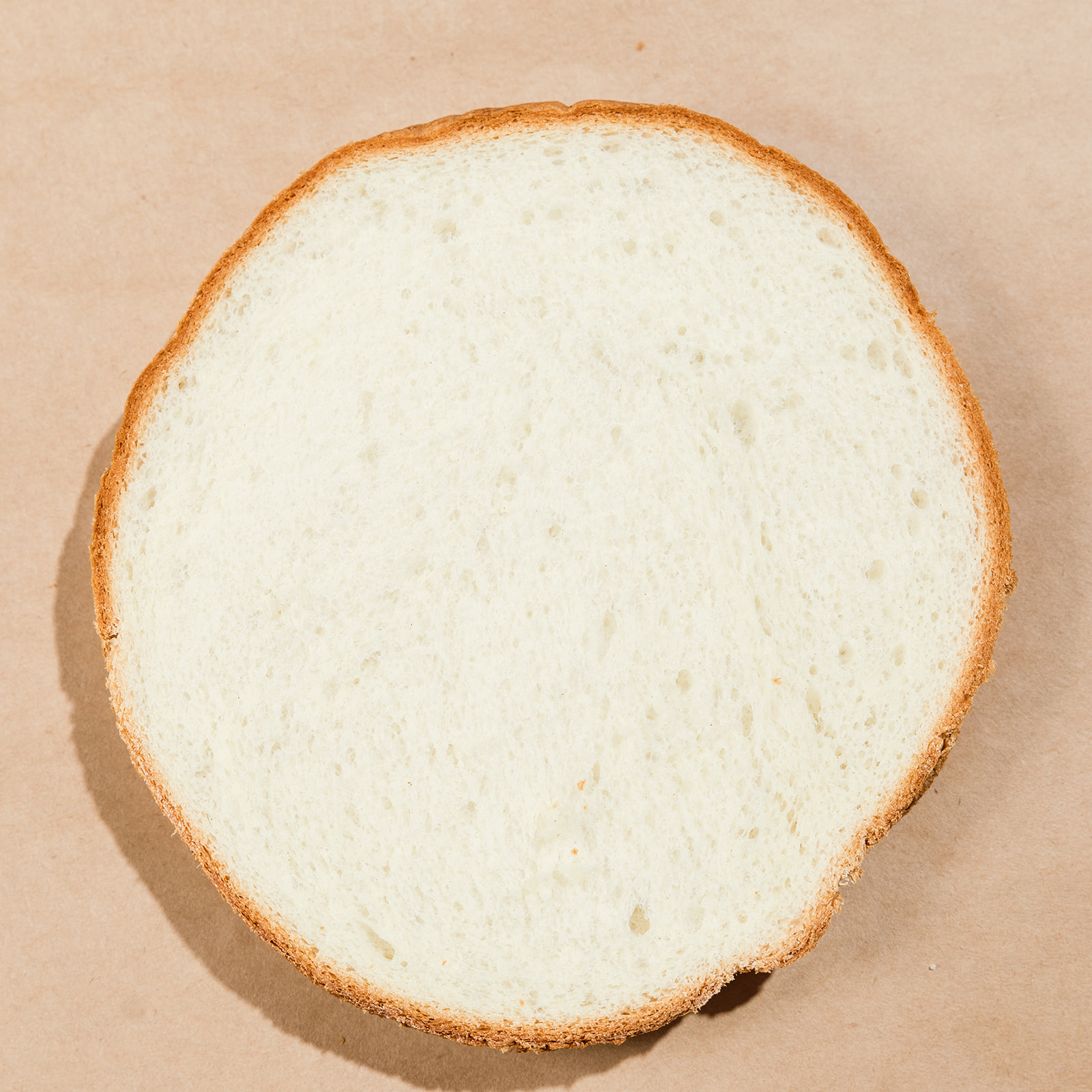 Round cross-section slice of La Segunda white bucket bread, pale even crumb.